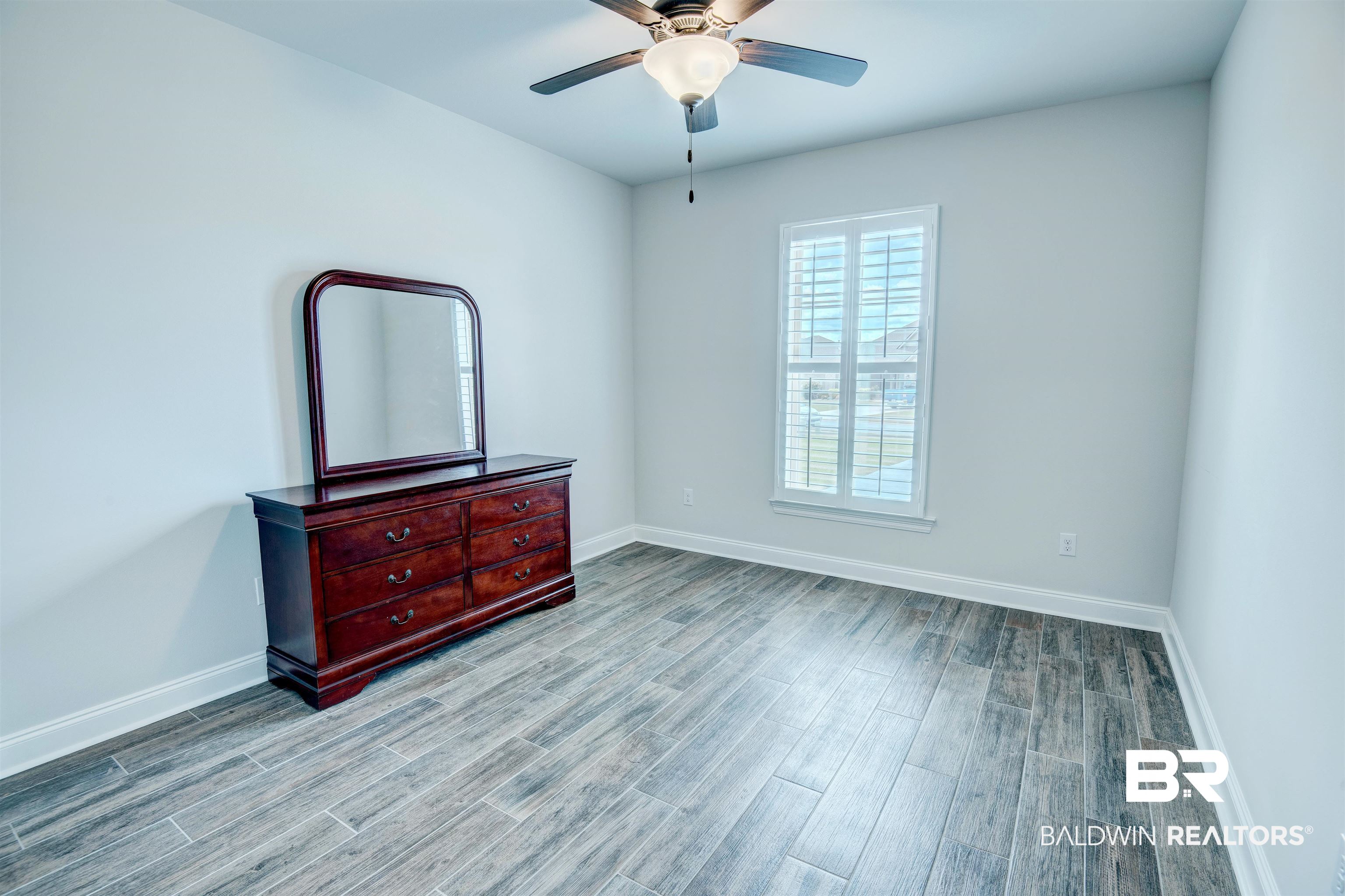 9843 Chipper Lane Foley, AL 36535 - Photo 23 of 34 Unfurnished bedroom featuring baseboards, wood finished floors, and ceiling fan