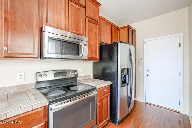 a kitchen with stainless steel appliances granite countertop a refrigerator stove and microwave