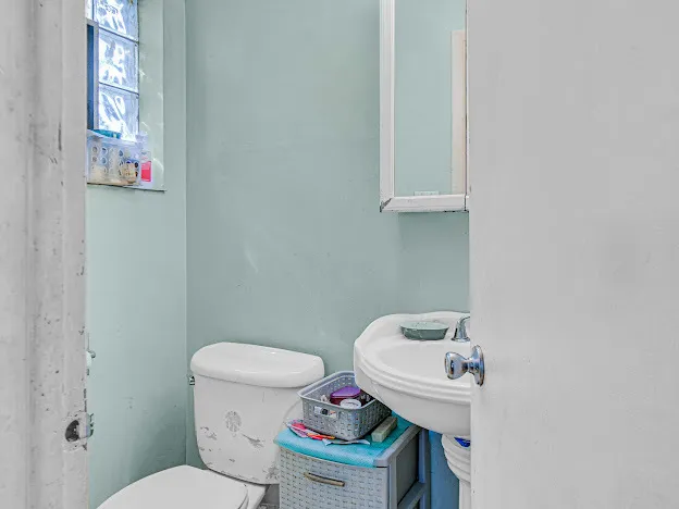 a white toilet sitting next to a bathroom sink