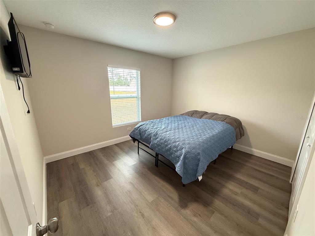 3791 Southwest 166th Pl Road Ocala, FL 34473 - Photo 18 of 43 a bedroom with a bed and flat screen tv