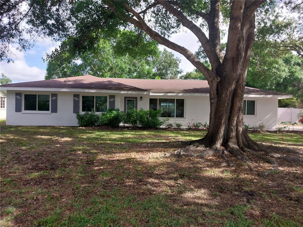 a view of a house with yard and tree s