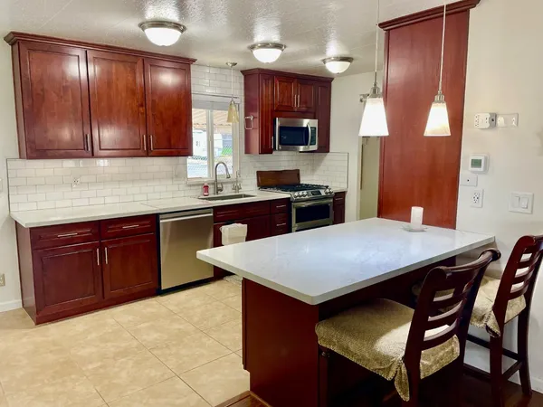 a kitchen with a stove a sink refrigerator and cabinets