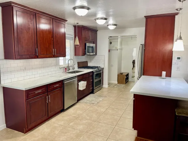 a kitchen with a sink a cabinets and refrigerator