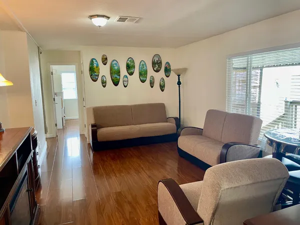 a living room with furniture and a wooden floor