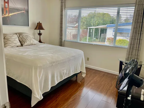 a bedroom with a bed and a large window