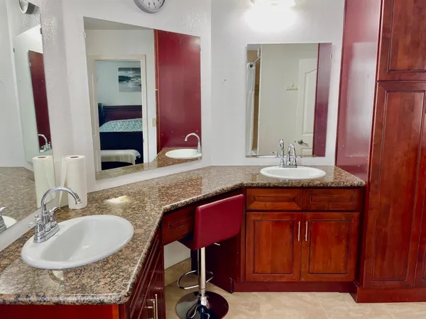 a bathroom with a granite countertop sink and a mirror