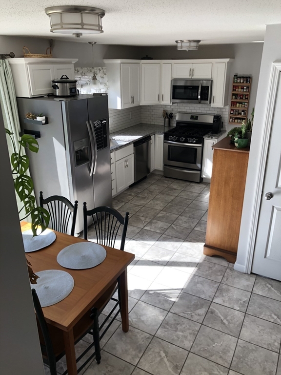 61 Southern Road Springfield, MA 01129 - Photo 13 of 35 a kitchen with stainless steel appliances kitchen island granite countertop a table chairs and a refrigerator
