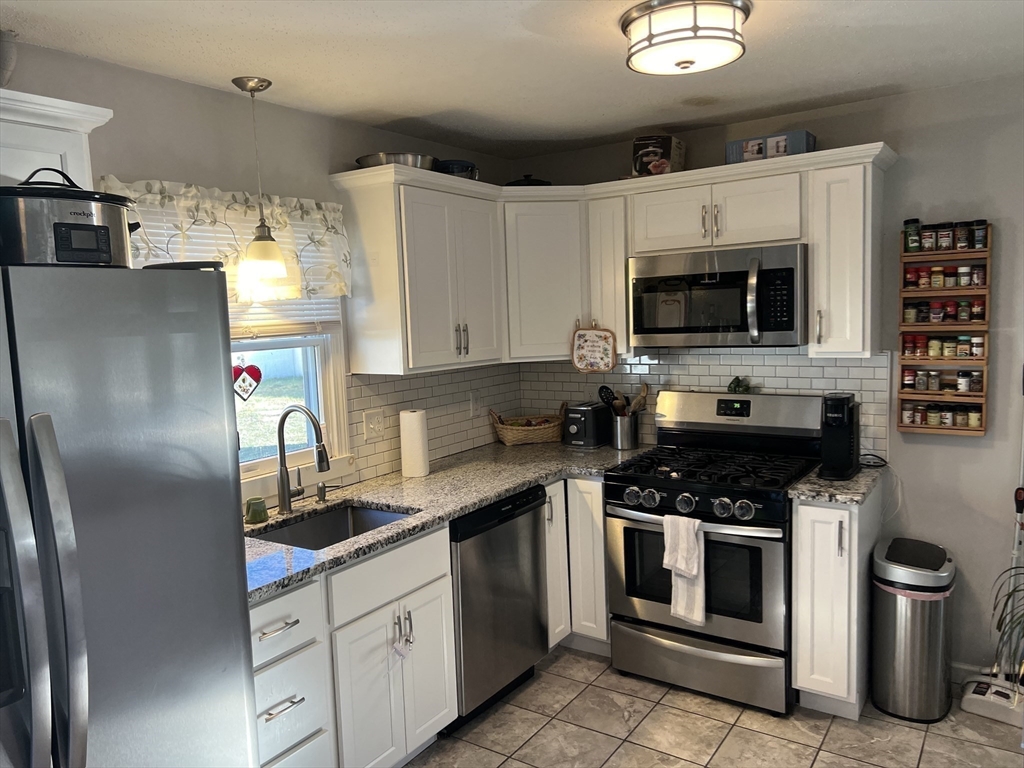 61 Southern Road Springfield, MA 01129 - Photo 10 of 35 a kitchen with stainless steel appliances a stove a sink a microwave and cabinets