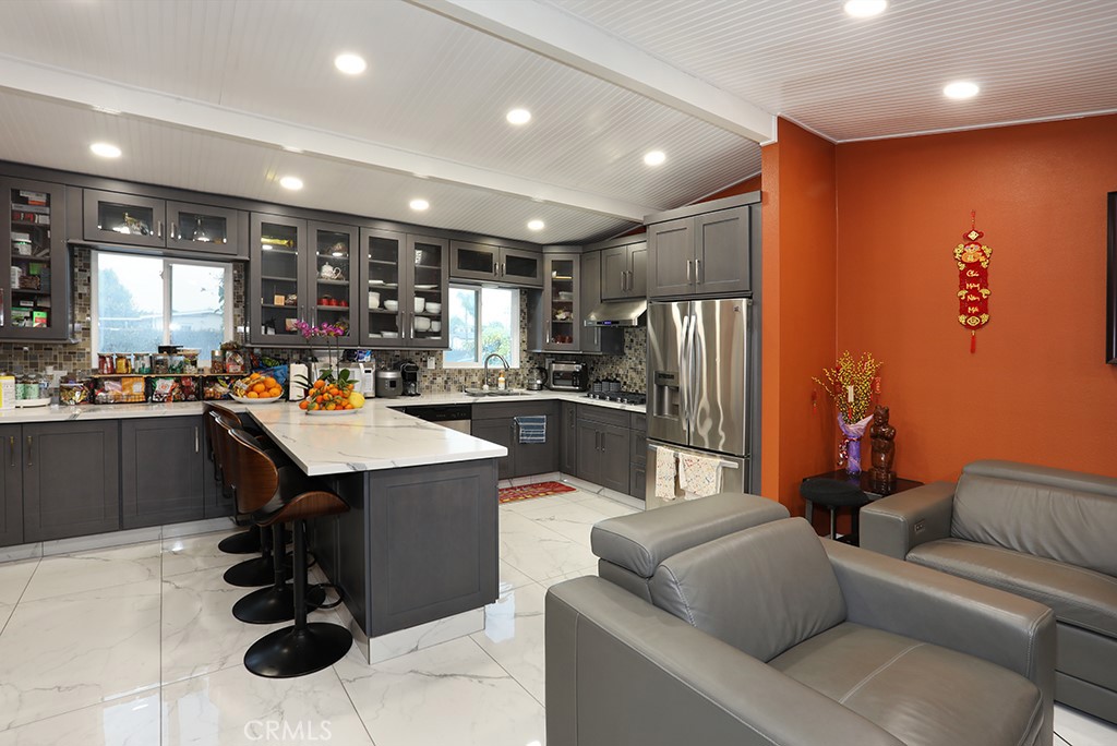 9802 Chanticleer Road Anaheim, CA 92804 - Photo 9 of 31 a kitchen with stainless steel appliances kitchen island granite countertop a refrigerator and a sink