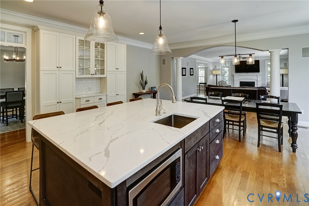 1295 Hermitage Road Manakin-Sabot, VA 23103 - Photo 31 of 55 a large kitchen with kitchen island a stove a sink a oven and a dining table with wooden floor