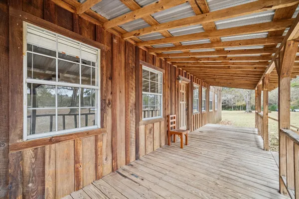 a view of a porch with wooden floor and windows