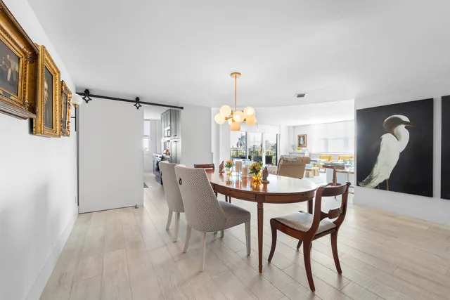 a dining room filled chandelier and wooden floor