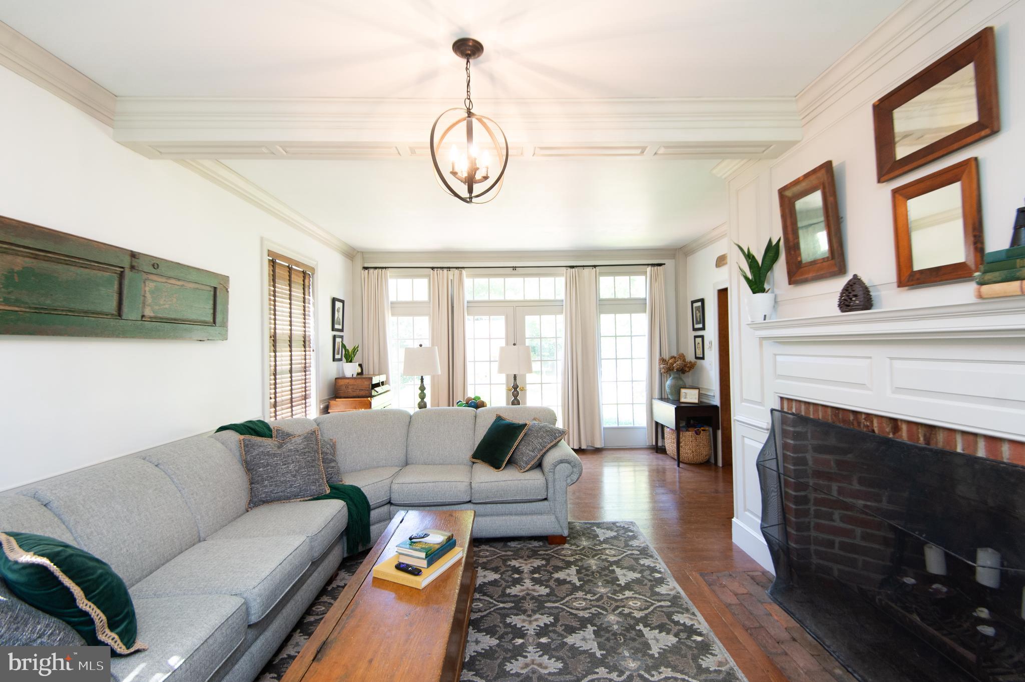 11 Shawnee Road Cambridge, MD 21613 - Photo 2 of 56 a living room with furniture a fireplace and a floor to ceiling window