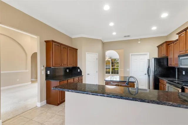 a kitchen with a sink a counter top space stainless steel appliances and cabinets