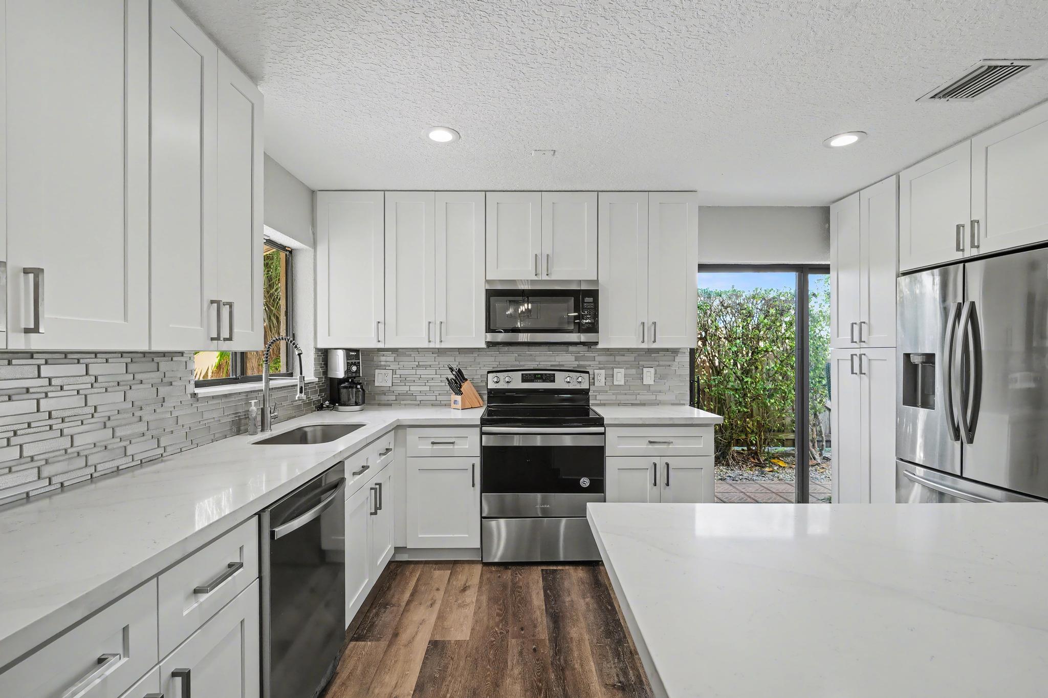 7855 Stanway Place Boca Raton, FL 33433 - Photo 5 of 24 a kitchen with stainless steel appliances a refrigerator sink and microwave