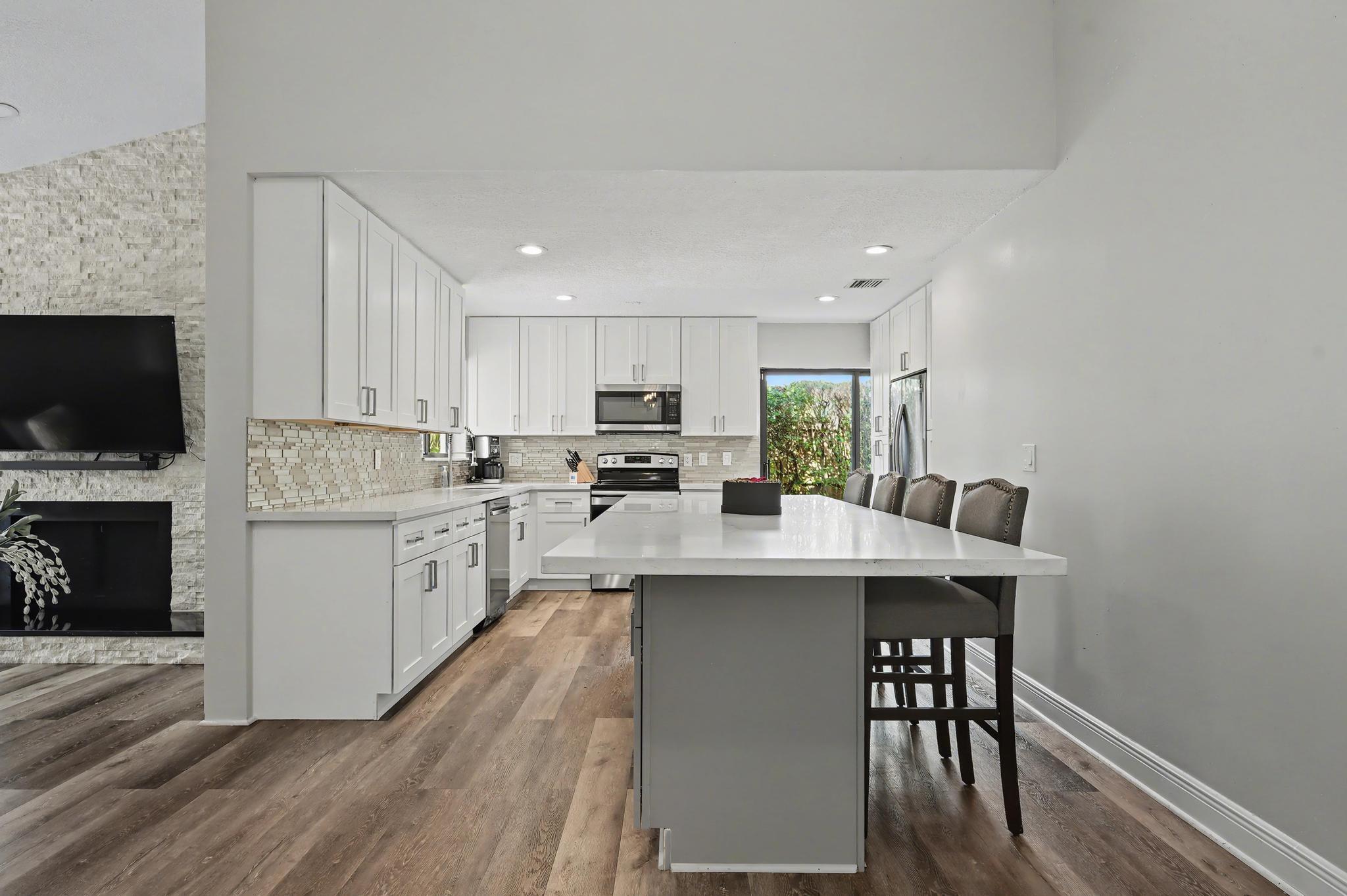 7855 Stanway Place Boca Raton, FL 33433 - Photo 6 of 24 a kitchen with a sink a microwave a stove and cabinets