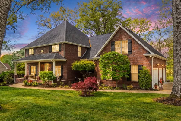 a front view of a house with a yard and potted plants