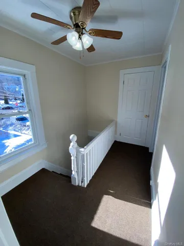 an empty room with windows and fan