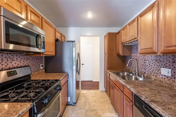 a kitchen with stainless steel appliances granite countertop a stove a sink and a microwave