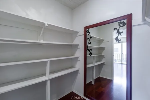 a view of a hallway with wooden floor and closet