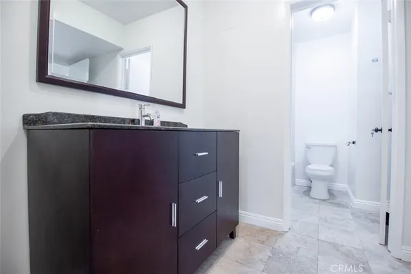 a bathroom with a sink a toilet and a mirror