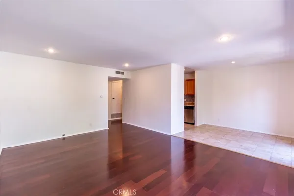 an empty room with wooden floor and natural light