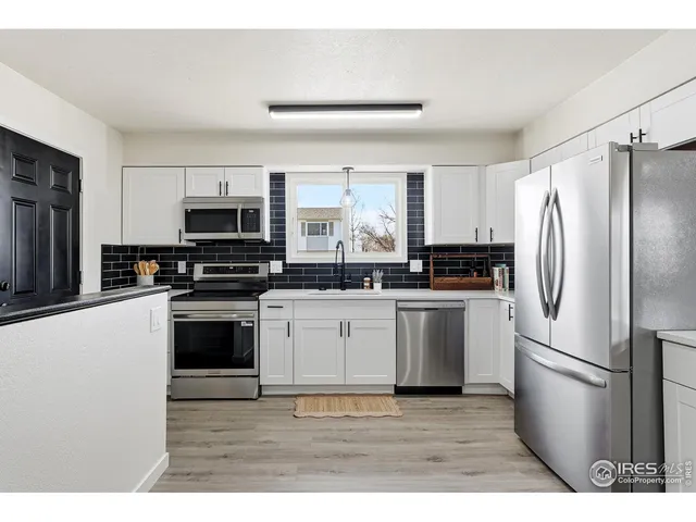 a kitchen with stainless steel appliances a refrigerator sink and microwave