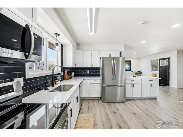 a kitchen with a sink stainless steel appliances and white cabinets