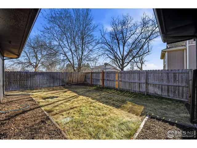 a view of backyard with wooden fence