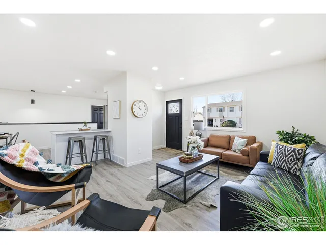 a living room with furniture and a dining table with wooden floor