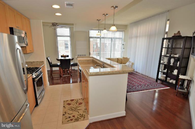 3650 South Glebe Road, Unit 638 Arlington, VA 22202 - Photo 11 of 24 a kitchen with stainless steel appliances granite countertop a refrigerator a sink a stove and a wooden floors