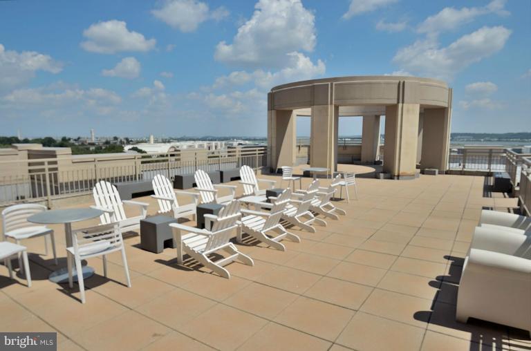3650 South Glebe Road, Unit 638 Arlington, VA 22202 - Photo 19 of 24 a view of a patio with table and chairs and potted plants
