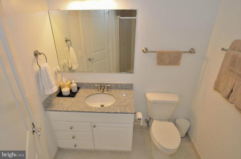 3650 South Glebe Road, Unit 638 Arlington, VA 22202 - Photo 9 of 24 a bathroom with a granite countertop toilet sink and mirror