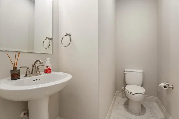 a bathroom with a toilet a sink and mirror