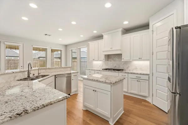 a kitchen with stainless steel appliances granite countertop refrigerator sink and cabinets