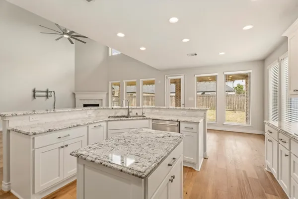 a kitchen with center island wooden floor and a sink