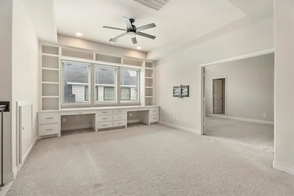 an empty room with windows and cabinet