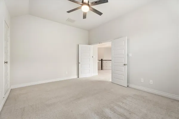 an empty room with closet and ceiling fan