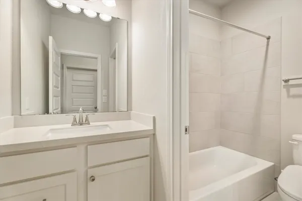 a bathroom with a bathtub a sink a toilet and a mirror