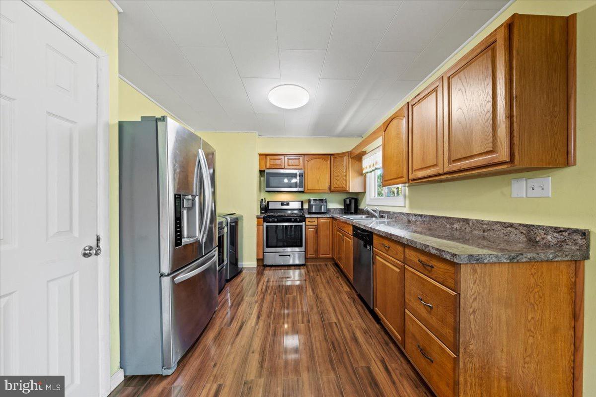 3 High Ridge Drive Pemberton, NJ 08068 - Photo 5 of 24 a kitchen with stainless steel appliances granite countertop a refrigerator a sink dishwasher a stove with wooden cabinets and floor