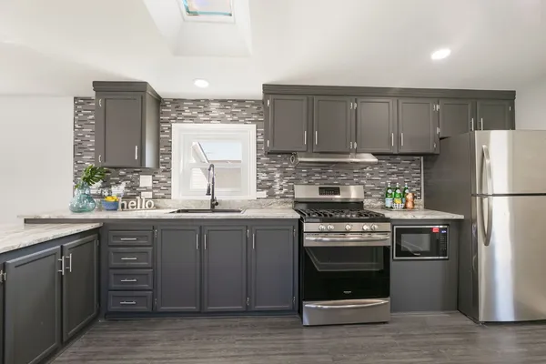 a kitchen with stainless steel appliances granite countertop a stove a refrigerator and a sink