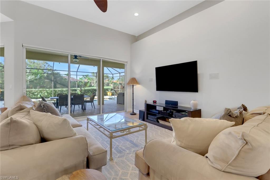 6757 Bent Grass Drive Naples, FL 34113 - Photo 6 of 27 a living room with furniture and a flat screen tv