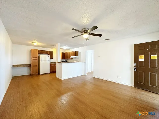 a view of a kitchen with a sink a refrigerator and a stove top oven