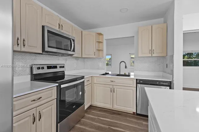 a kitchen with white cabinets and stainless steel appliances
