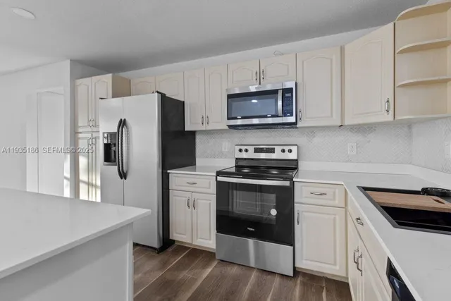 a kitchen with stainless steel appliances white cabinets and a refrigerator