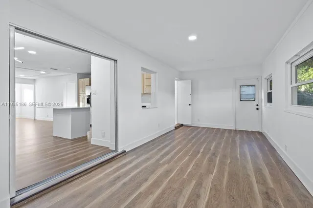 a view of a big room with wooden floor and windows