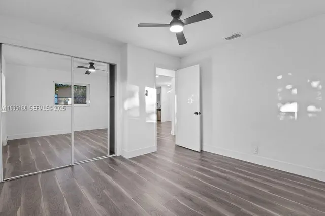 a view of empty room with wooden floor