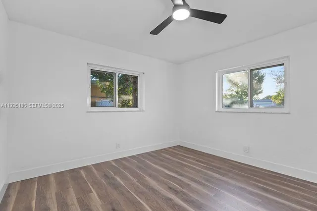 a view of empty room with wooden floor