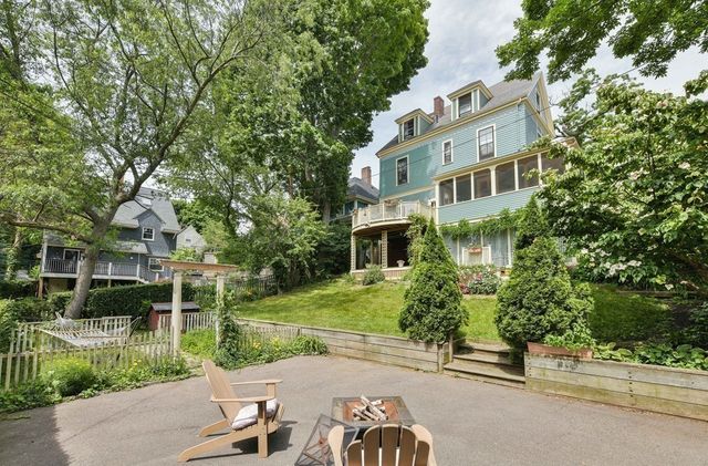 a view of a patio with table and chairs potted plants and floor to ceiling window