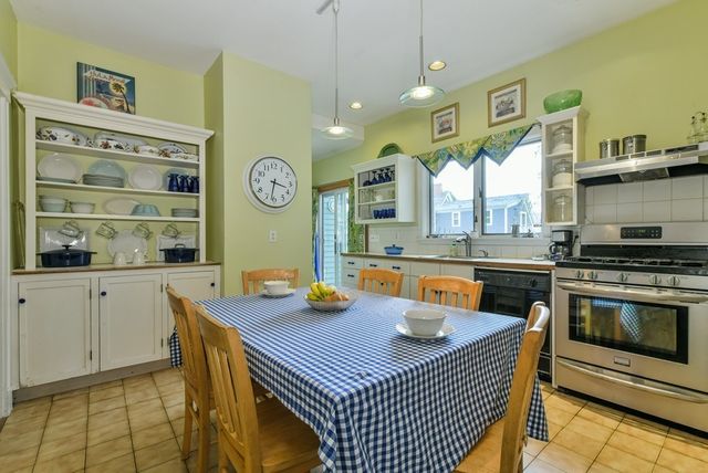 a kitchen with a sink a stove and wooden cabinets
